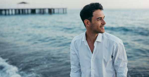 Man at beach smiling and looking away