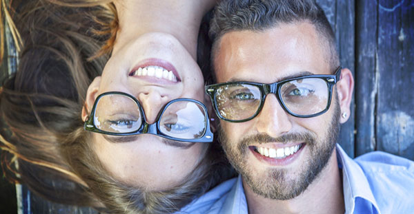 Young couple with glasses, smiling