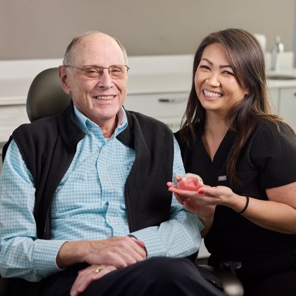 Dental hygienist and patient smiling together