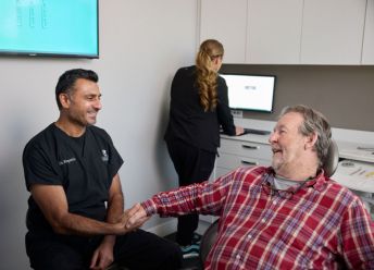 Dr Ruparelia shaking hands with a happy CascadesONE Dental patient